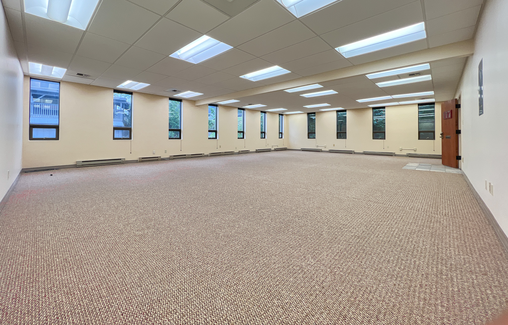 Interior of RSD Properties' Suite 102 at the 750 W 2nd Avenue office building in Anchorage, Alaska. There are several windows all around, tan carpeting and a drop ceiling