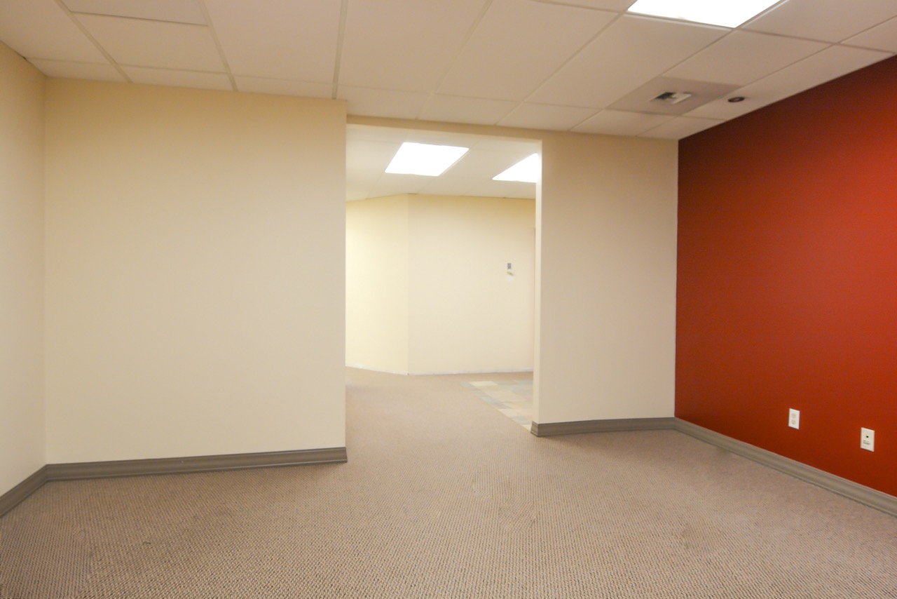 Interior of RSD Properties' Suite 101 at the 750 W 2nd Avenue commercial office building in Anchorage, Alaska. Tan walls on the left and center, orange wall to the right, hallway entrance center.