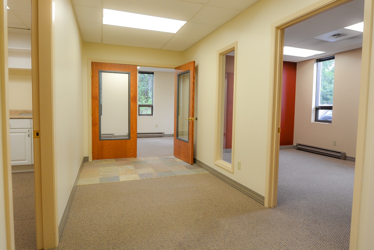 Interior entrance of RSD Properties' , Suite 101 in the 750 W 2nd Avenue commercial office building in Anchorage, Alaska. Offices left and right and exit doors at the center.