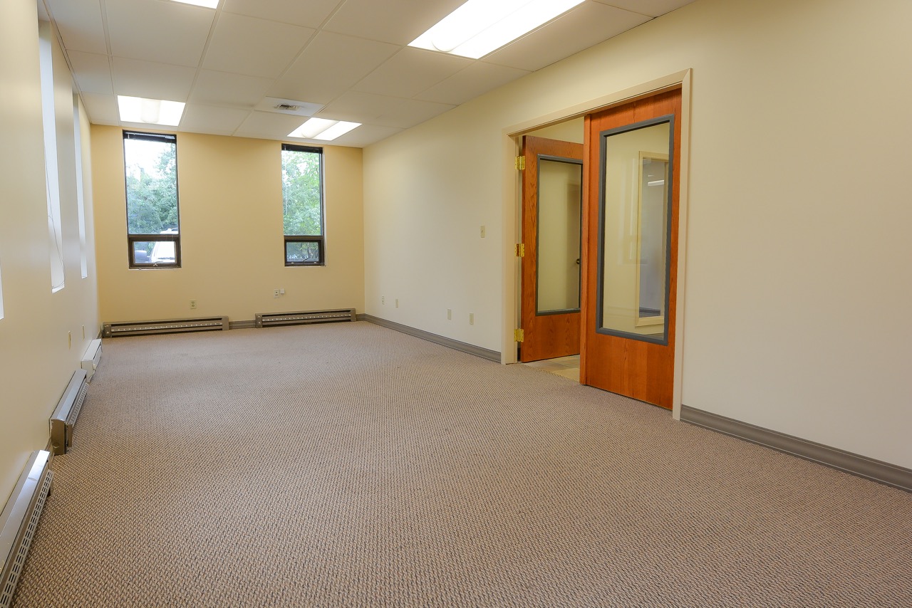 Interior of RSD Properties' Suite 101 in the 750 W 2nd Avenue commercial office building in Anchorage, Alaska. Tan walls and windows on the left, entrance doors on the right