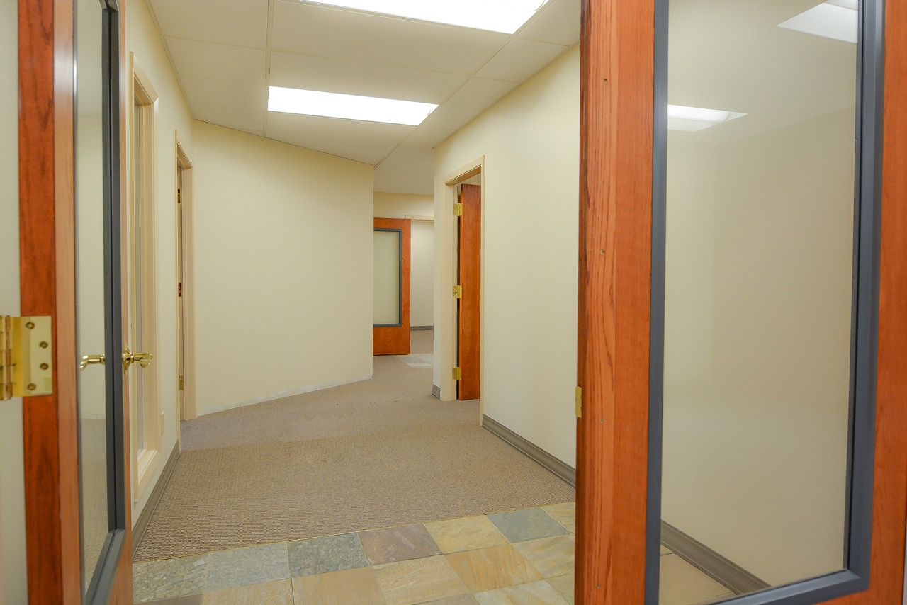 Interior hallway of RSD Properties' Suite 101 in the 750 W 2nd Avenue commercial office building in Anchorage, Alaska. Tan walls and carpets and several office entrances