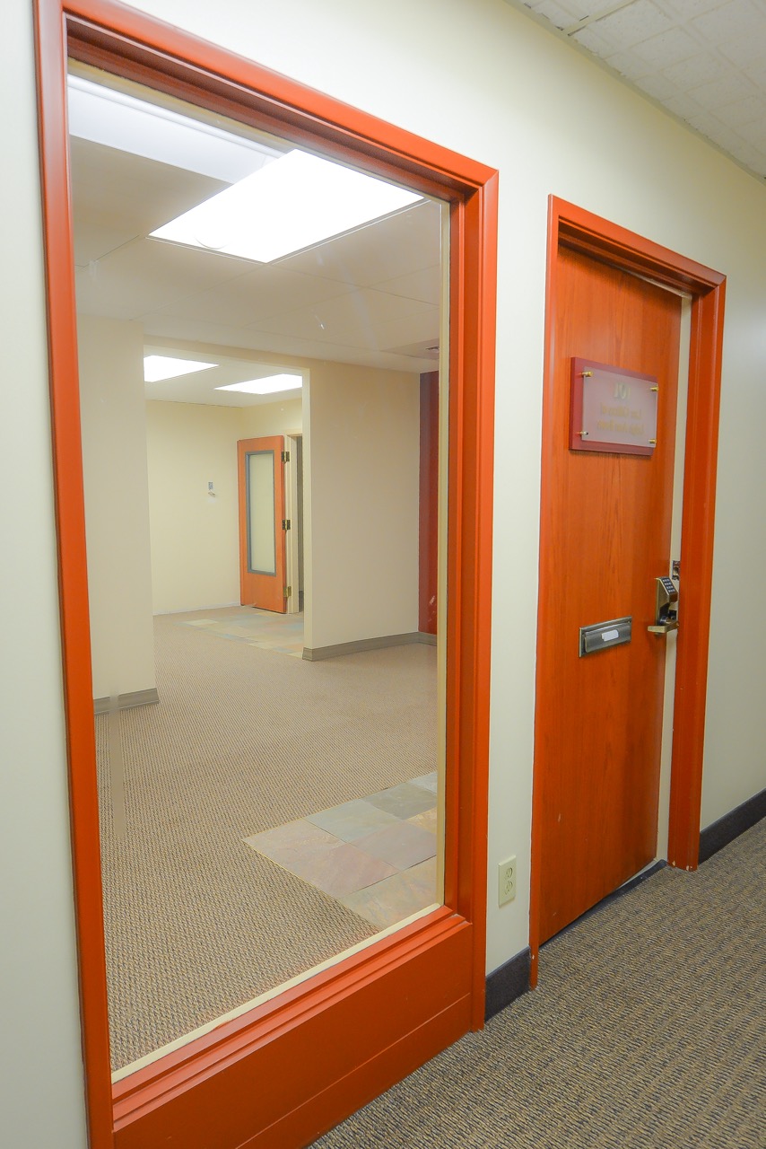 Interior entrance to RSD Properties' Suite 101 in the 750 W 2nd Avenue commercial office building in Anchorage, Alaska. Tan walls and orange windowsills and door
